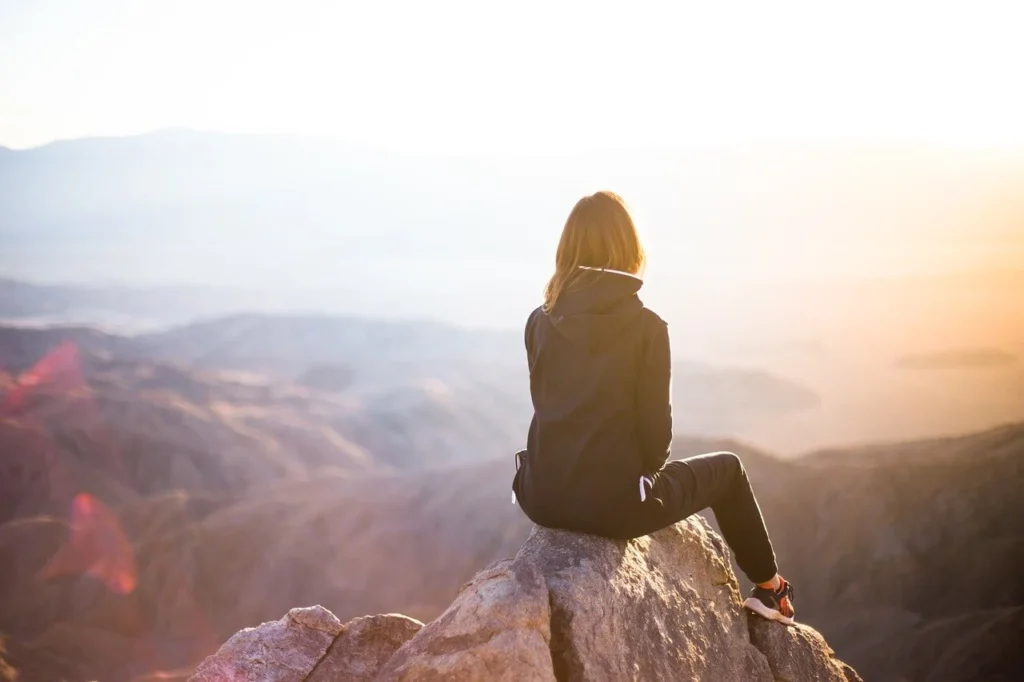 Hiker overlooking a scenic mountain view at sunset