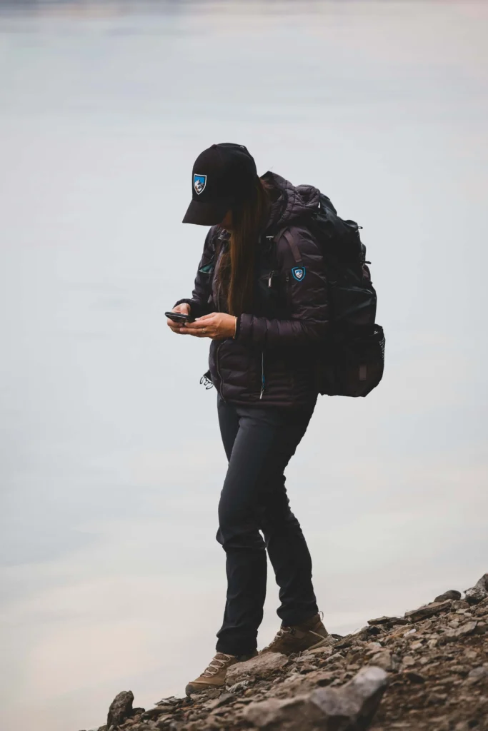 Hiker using a GPS app and compass on a trail
