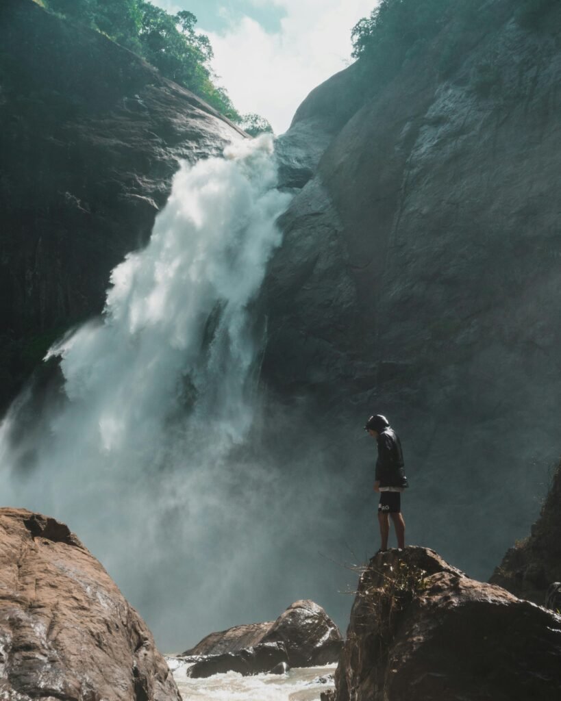 hiker on a rock by a waterfall
