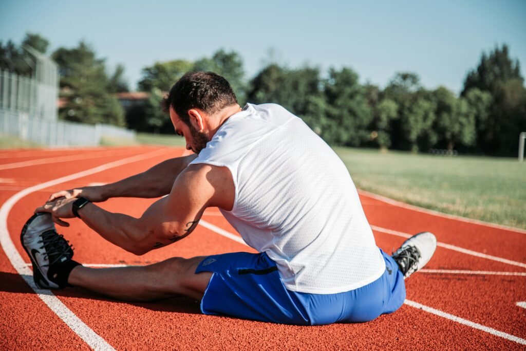 Person stretching on a running track to improve mobility