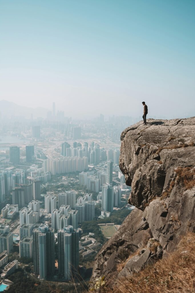 urban hiking. person on a cliff above city